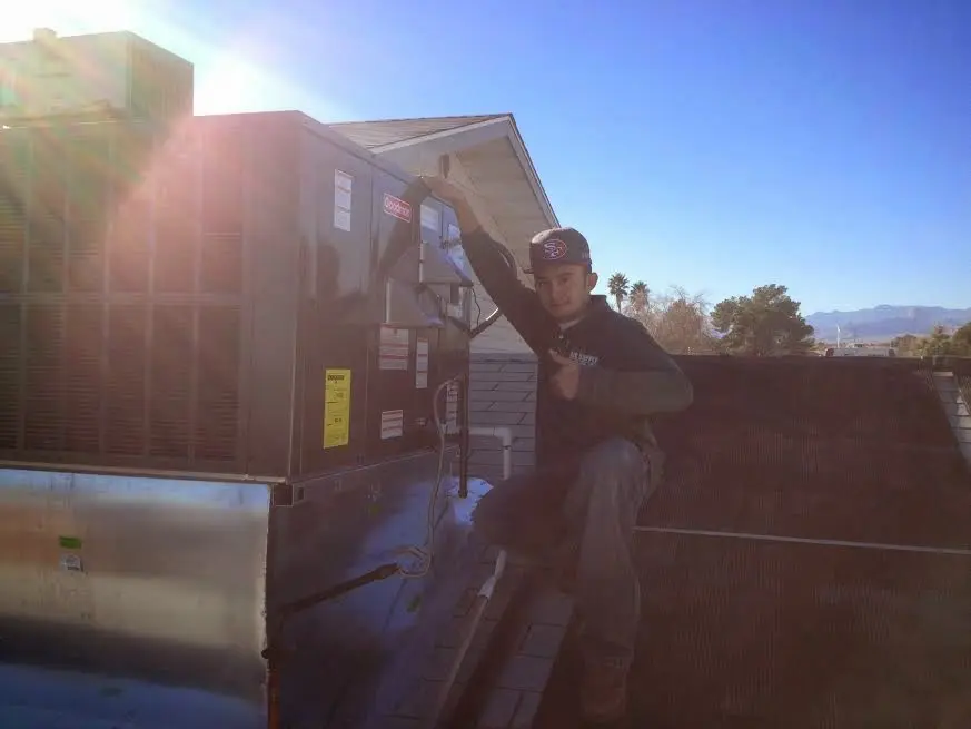 HVAC technician performing Heat Pump Repair on a rooftop unit in Spearfish